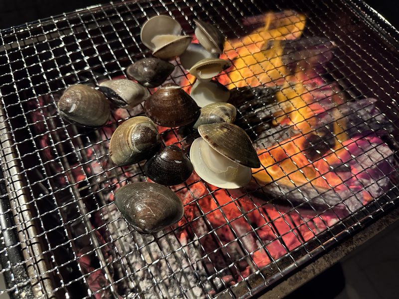 自宅バーベキューの網の上で焼ける貝